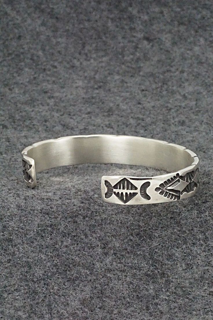 This sterling silver bracelet was made by Navajo silversmith Elvira Bill. The inside is signed Elvira Bill and stamped sterling.Size: 5 7/8" (will fit up to a 7 3/8" wrist)Gap: 1 1/2"Width: 3/8"Free shipping on all orders! We ship with USPS and always include tracking. All orders ship within a day of payment.Returns are accepted up to 30 days after you receive your order. Just send us a message. Our shop offers cash back or store credit. The item must be returned in new condition. Adjustable Artisan Sterling Silver Bracelet, Artisan Sterling Silver Bracelet With Oxidized Finish, Adjustable Sterling Silver Bracelet In Antique Silver, Antique Silver Sterling Silver Bangle Bracelet, Sterling Silver Etched Bangle Bracelet, Adjustable Sterling Silver Cuff Bracelet With Oxidized Finish, Etched Sterling Silver Bangle, Bohemian Antique Silver Sterling Silver Bracelet, Bohemian Antique Sterling Silver Bracelet