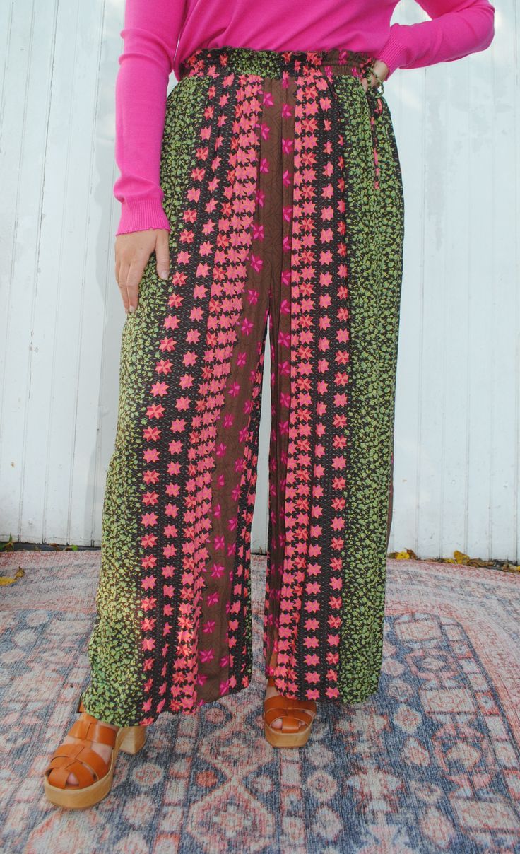 Get ready to harvest some compliments in these Boho-inspired pants! With a unique border print, elastic waist and hem, and side tie pockets, these pants offer both style and functionality. Perfect for a playful and fun-loving fashionista, these pants will make a statement while keeping you comfortable. -100% Rayon Hand Wash Cold Do Not Bleach Lay Flat to Dry Green Parachute Pants With Elastic Waistband For Fall, Multicolor High-waisted Wide Leg Pants With Elastic Waistband, Multicolor Wide-leg Pants With Elastic Waistband, Multicolor Wide-leg Bottoms With Elastic Waistband, Multicolor Ankle-length Wide Leg Pants With Elastic Waistband, Casual Multicolor Floral Print Pants, Bohemian Ankle-length Floral Pants, Bohemian Vibrant Print Vacation Bottoms, Bohemian Bottoms With Vibrant Print For Vacation