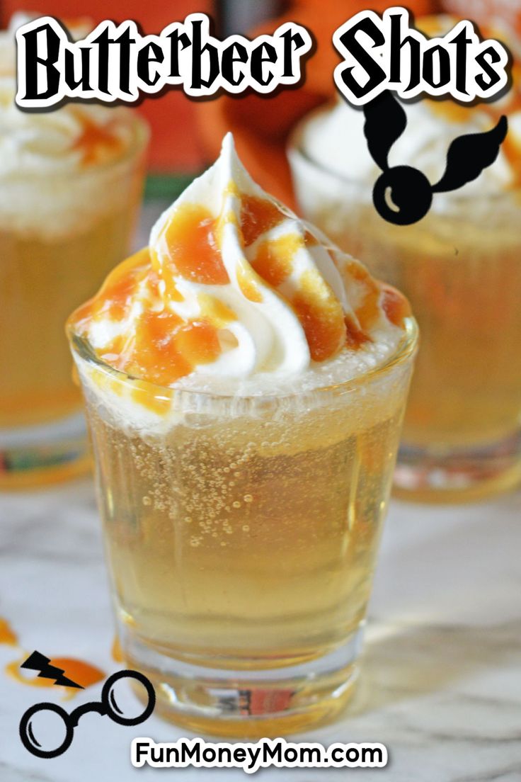 two shots with whipped cream and orange peels in them on top of a table