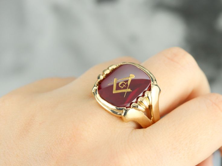 "This large vintage red glass Masonic ring has amazing, yet simply detailed shoulders, rising up from the shank and bending around the corners of the stone. The center is a classic red glass cabochon, inlaid with the gold Masonic symbol, with a nice flat profile. This ring has a substantial feel to it, and makes for a classic Masonic piece! Metal: 14K Yellow Gold Gem: Red Glass Cabochon, Gold Inlaid Masonic Symbol Gem Measures: 16mm x 14mm, Square Cushion Cut Size of Ring: 10 Marks: \"14K\" and Collectible Red Rings With Polished Finish, Heirloom Red Signet Ring With Polished Finish, Classic Red Signet Ring For Formal Occasions, Classic Red Engraved Jewelry, Classic Red Ruby Jewelry, Collectible Red Engraved Ring, Red Engraved Signet Ring For Formal Occasion, Formal Red Engraved Signet Ring, Classic Red Intaglio Jewelry