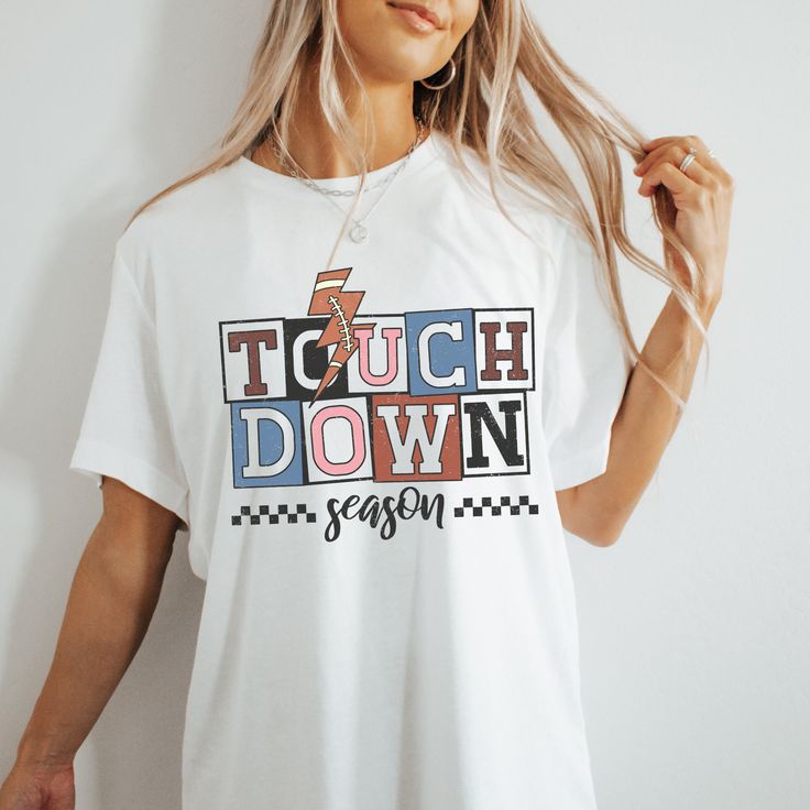 Wear this Touchdown Season football Tshirt on game day, to football parties or just to show how much you love football. Welcome to my store! Everyone needs the perfect t-shirt to complement an everyday, laid-back look. The ideal top for so many occasions, this lightweight cotton tee will keep you comfy and looking smart. * 100% combed and ring-spun cotton (Heather colors contain polyester) * Fabric weight: 4.2 oz/yd² (142 g/m²) * Pre-shrunk fabric * Side-seamed construction * Shoulder-to-shoulde White Casual Top For Tailgating, Casual White Top For Tailgating, White T-shirt For Game Day, Football Season Fan Apparel Tops With Graphic Print, Game Day Graphic Print Top For Sports Season, Cheerleading Fan Apparel Tops For Football Season, Crew Neck Tops For Football Season Game Day, Graphic Print Tops For Game Day And Sports Season, Sporty Crew Neck Top For Tailgating