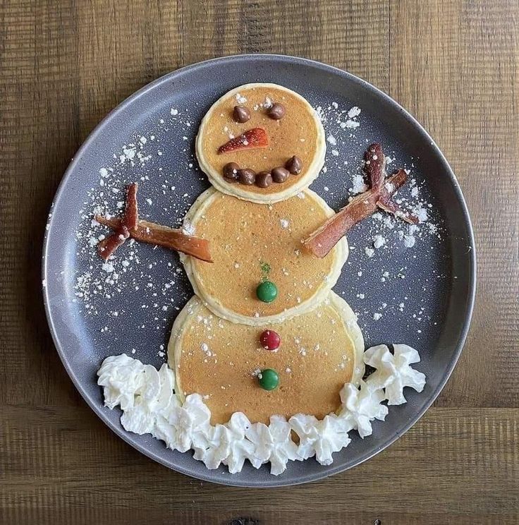 a plate topped with pancakes covered in icing and snowmen on top of it