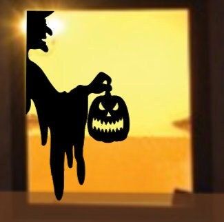 the silhouette of a man holding a jack o lantern in front of an open window