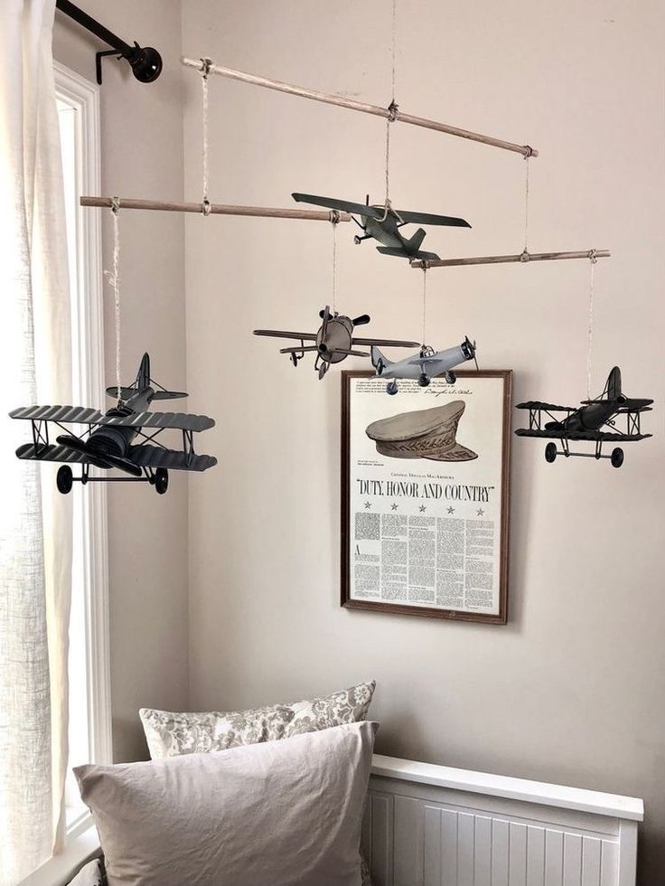 some airplanes are hanging from the ceiling above a bed