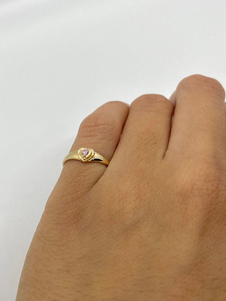 This cute small 14K gold heart signet ring is the perfect size for a baby, child, or pinky ring for women. The center stone is a simulated pink or white diamond (Cubic Zirconia). The ring is made of 100% 14K gold. It's a beautiful ring for a little girl or a gorgeous pinky ring. Ring pictured on a small child's hand and woman's 2 1/2 pinky finger Stamped 14K gold Cubic Zirconia Stone Small sized ring Visit us on Instagram @agoldmindjewelry for our custom jewelry designs and newest listings ▬ All Pinky Gold Ring, Gold Heart Ring For Valentine's Day, Cute Gold Heart Ring For Valentine's Day, Cute Gold Rings For Valentine's Day, Pinky Signet Ring Women, Cute Heart Ring For Valentine's Day Anniversary, Dainty Stackable Heart Ring For Valentine's Day, Cute Gold Heart Promise Ring, Dainty Valentine's Day Stackable Heart Ring