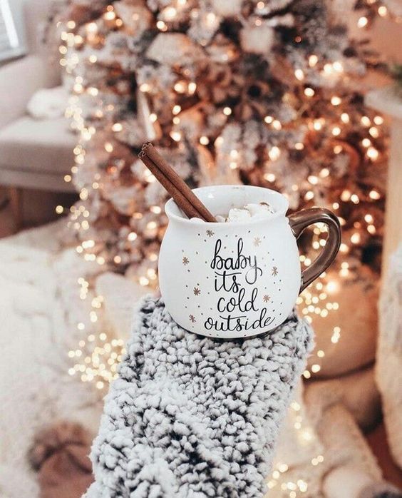 two mugs sitting on top of each other in front of a christmas tree