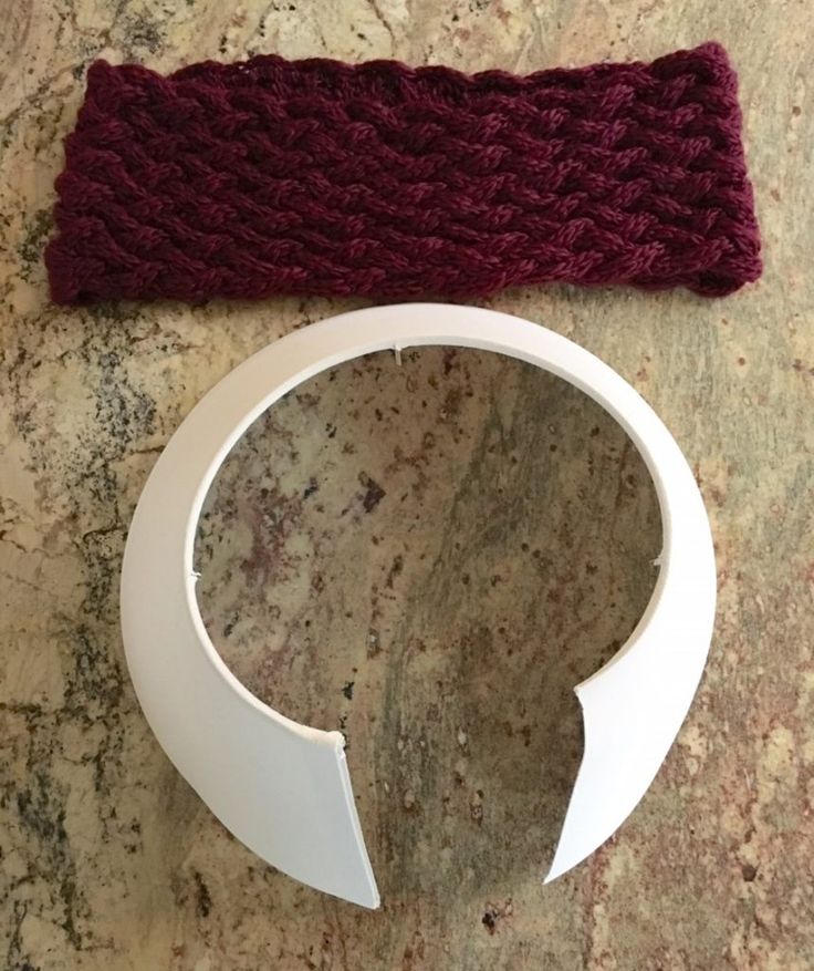 a knitted headband sitting on top of a table next to a white object