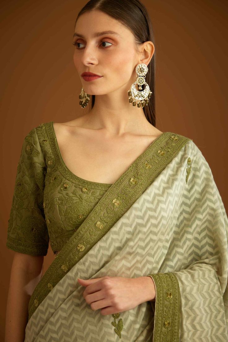 Editor's Note This ensemble features a green anchor thread embroidered chanderi jacquard sari with an embroidered blouse and border. The sari is intricately embellished with anchor thread embroidery that creates a beautiful texture and contrast against the green jacquard fabric. The blouse is also embroidered with similar anchor thread work and complements the sari perfectly. Color: Green Fabric: Chanderi jaquard & cotton silk Embroidery details: Anchor thread embroidery Components: Sari & blous Anchor Thread Embroidery, Green Sari, Jacquard Saree, Blouse Yoke, Anchor Threads, Embroidered Motifs, Embroidered Saree, Casual Tunics, Sari Blouse