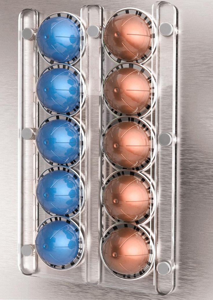 an egg carton with six blue and pink eggs in it on a metal surface