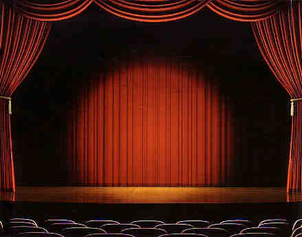 an empty stage with red curtains and chairs