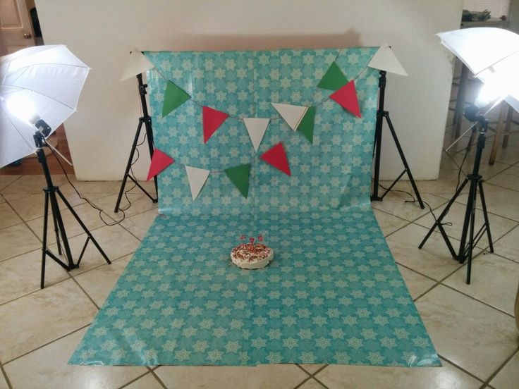 a cake sitting on top of a table in front of some photography equipment and umbrellas