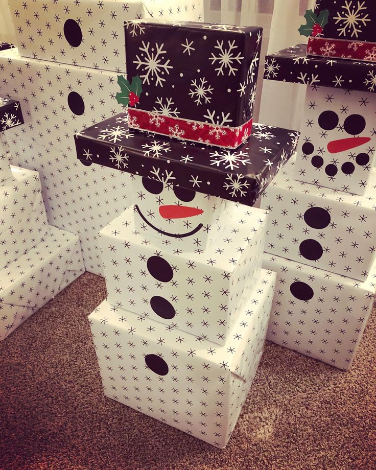 snowman made out of gift boxes sitting on the floor