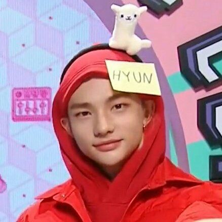 a young man with a red hoodie and a white teddy bear on top of his head