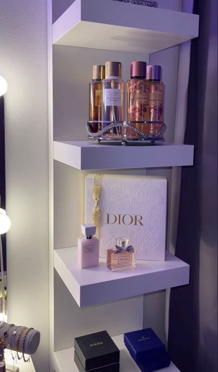 three white shelves with perfume bottles on them