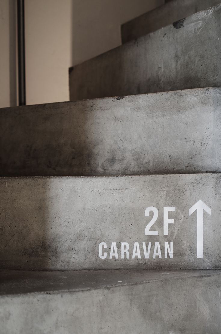 there is a sign on the stairs pointing to caravan and 2f streets