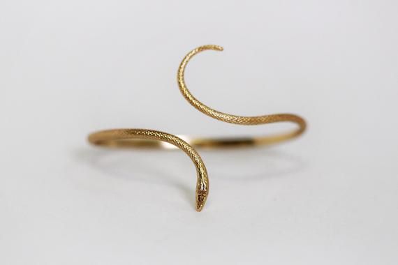 This dainty and detailed snake bracelet is made out of two connected snakes that are soldered to each other in the center, so on one edge you see the snakes head and on the other edge you see the second snake's tail. The material is flexible so it is very easy to adjust the size. Historically, snakes represent fertility or a creative life force. As snakes shed their skin through sloughing, they are symbols of rebirth, transformation, immortality, and healing. In ancient Egypt, the snake was used Elegant Snake-shaped Bangle For Gift, Elegant Snake Shape Bangle Gift, Elegant Snake Shape Bangle Perfect For Gift, Elegant Adjustable Snake Bangle, Elegant Snake-shaped Bangle As Gift, Adjustable Elegant Snake Ring As Gift, Adjustable Elegant Snake Ring For Gift, Elegant Adjustable Snake Ring As Gift, Elegant Adjustable Snake Ring