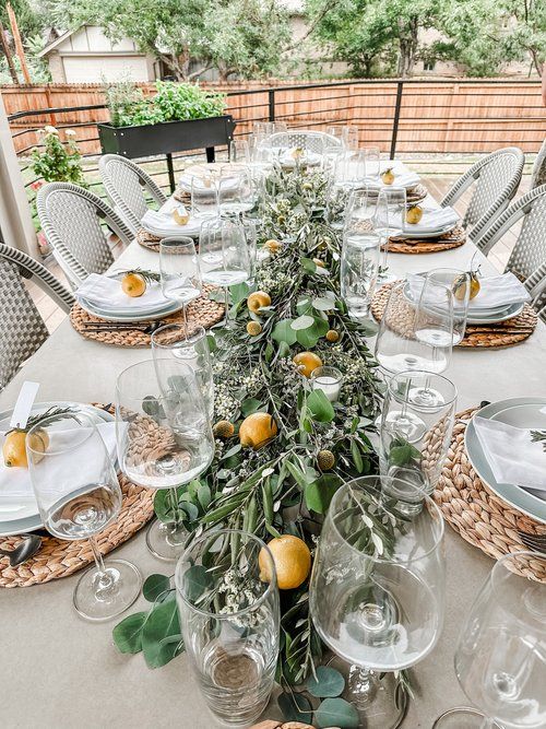 the table is set with plates, glasses and silverware for an elegant dinner party