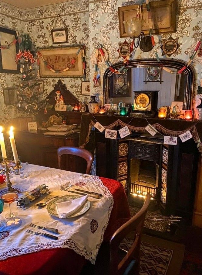 a dining room table is set with plates and glasses, candles, and pictures on the wall