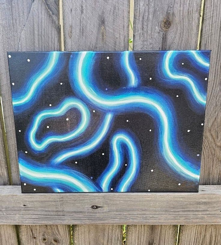 a painting on a wooden fence with blue and white swirls painted on it's surface