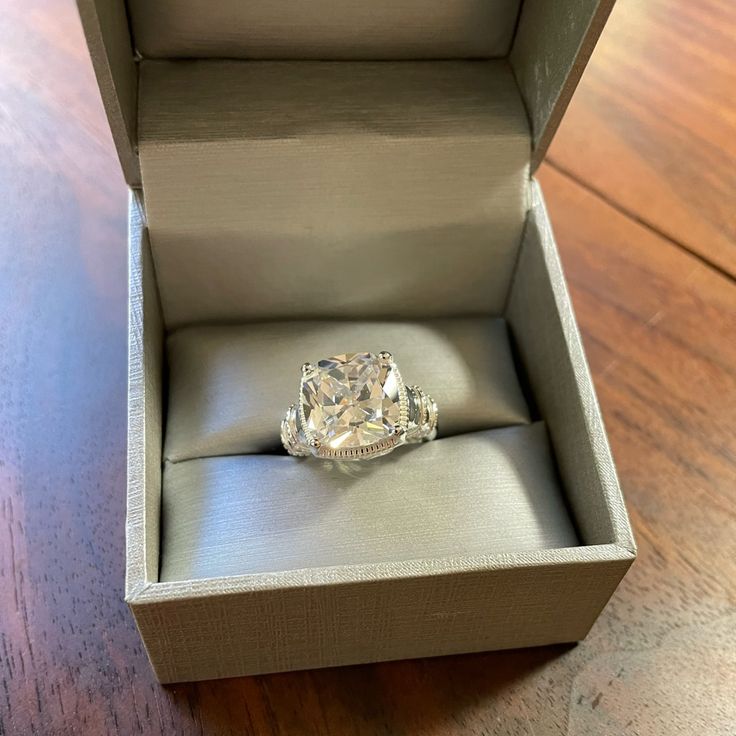 an engagement ring in a box on a wooden table