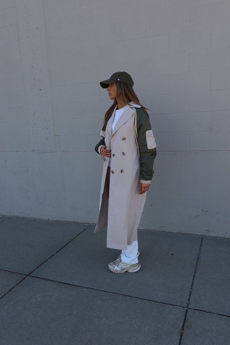 DETAILS: Our Khaki Combo Trench Coat is a maxi length coat. The unique aspect of this trench coat is the long sleeves that are a different windbreaker material with a little zipper pocket on the mid-arm on one size. This coat features a collared neckline with a relaxed fit silhouette, functional side pockets, and is fully lined. This coat has two rows of buttons and a wrap-around tie closure. This is made of a lightweight breathable woven material, that has little to no stretch. This collared co Trendy Long Outerwear With Pockets, Oversized Double-breasted Khaki Outerwear, Beige Military Style Long Sleeve Outerwear, Khaki Long Sleeve Gabardine Outerwear, Khaki Gabardine Long Sleeve Outerwear, Khaki Gabardine Outerwear, Long Gabardine Raincoat For Fall, Fall Gabardine Long Raincoat, Long Khaki Outerwear For Work