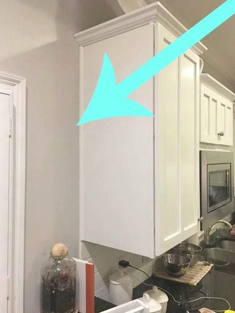 a kitchen with white cabinets and an arrow pointing to the left