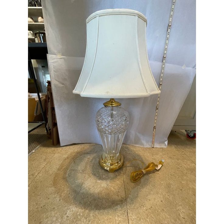 a lamp that is on top of a table next to a white pillow and chain