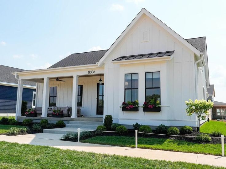 a white house with flowers in the window boxes