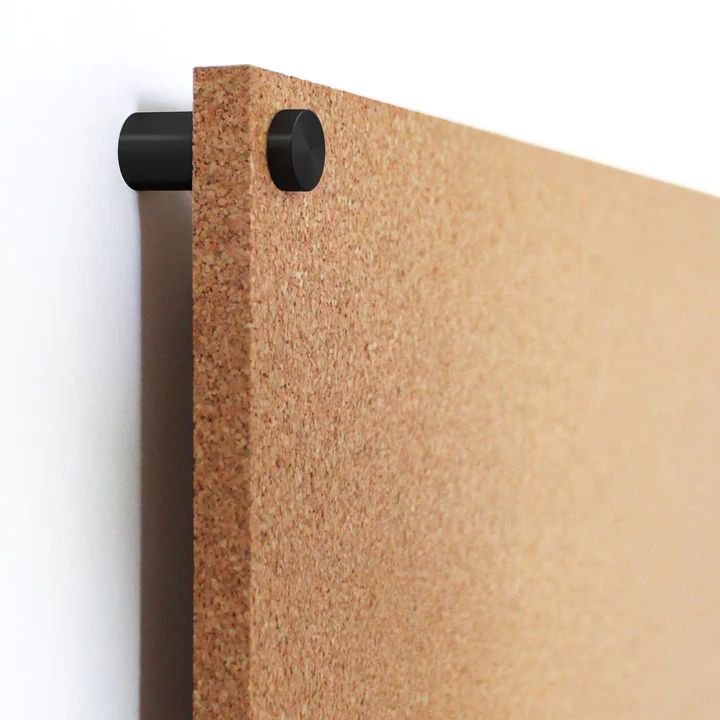 a close up of a cork board with two holes in it