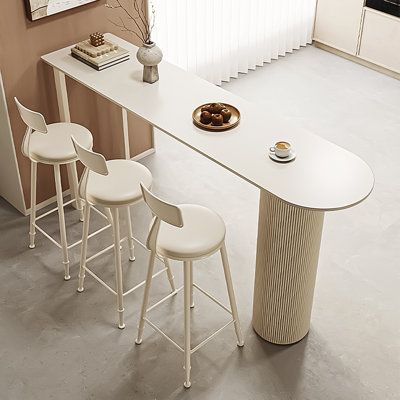 three white stools sitting at a counter in front of a painting on the wall