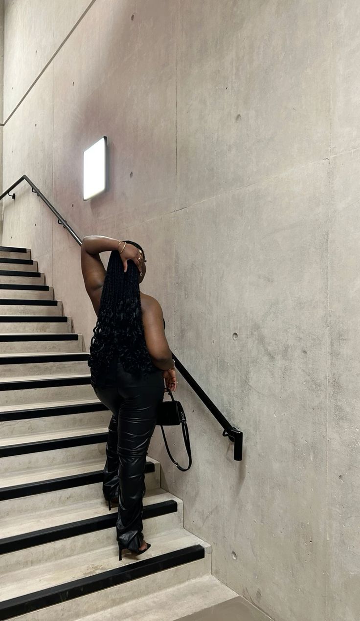 a woman walking up some stairs with her handbag