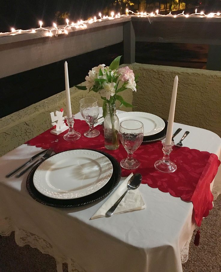 the table is set with white and red place settings