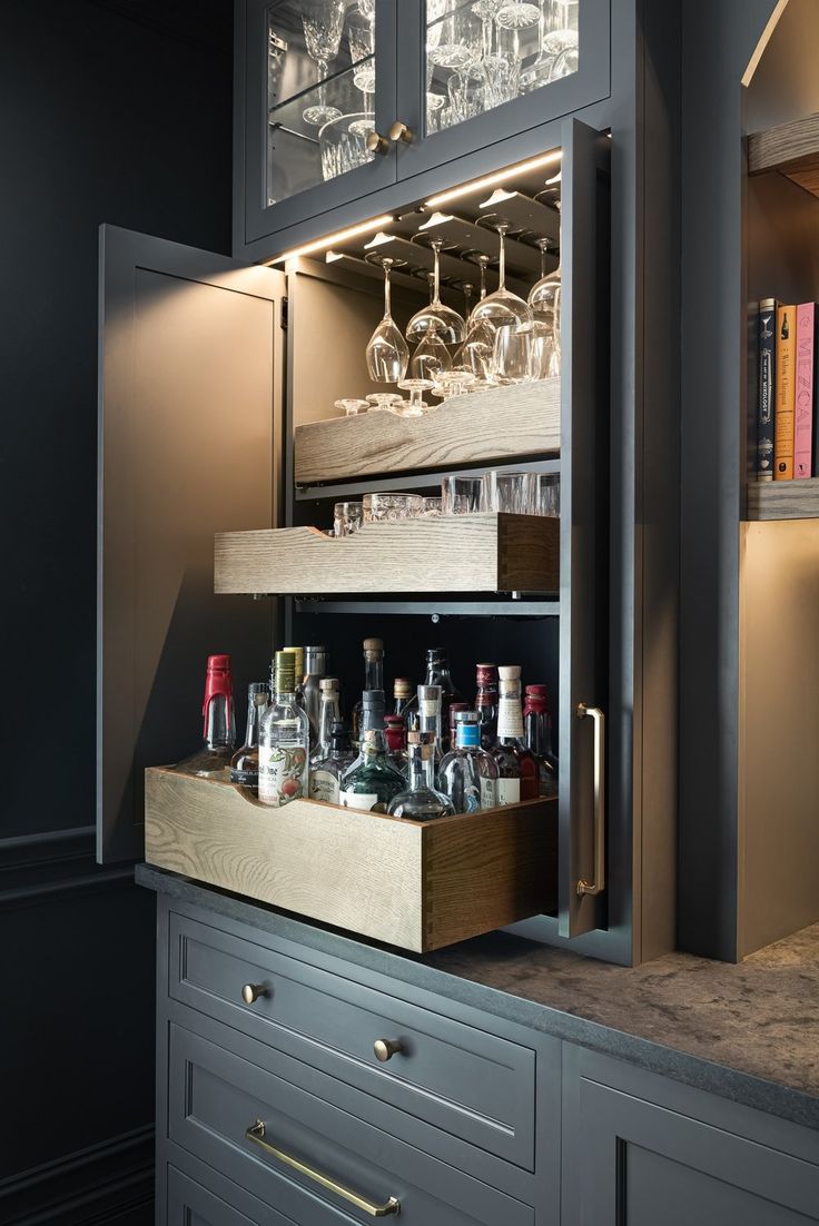 an open cabinet with bottles and glasses in it