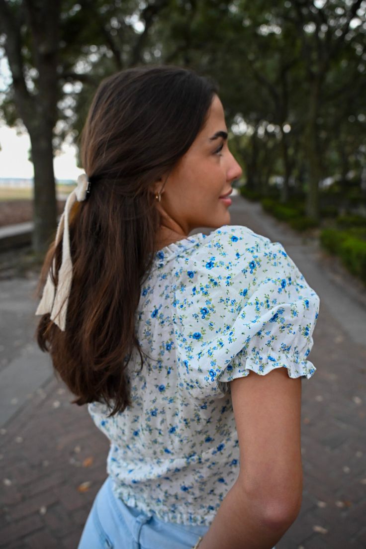 Meet me in the Fields Of Happy, ‘cause I’ve found the top of my dreams! Our newest blue floral print top is perfect for those easygoing spring days. This sweetly-seductive top features a sweetheart neckline, micro-ruffle edges and romantic puffed sleeves with elastic trim. Super cute blue floral print Micro-ruffle smocked sweetheart neckline Three layers of string ties with upside down v hemline Quality material (to avoid any see-through) Available in S,M,L. Model is 5’6 and wearing a size small Ditsy Floral Print Short Sleeve Tops For Garden Party, Short Sleeve Ditsy Floral Tops For Garden Party, Blue Floral Print Top For Garden Party, V-neck Ruffle Top For Garden Party, Blue Tops For Summer Garden Party, Spring Garden Party Tops With Puff Sleeves, Spring Garden Party Puff Sleeve Tops, Spring Ditsy Floral Print Tops For Garden Party, Blue Ditsy Floral Print Top For Day Out