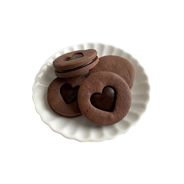 three heart shaped cookies are on a white plate with two hearts cut out of them