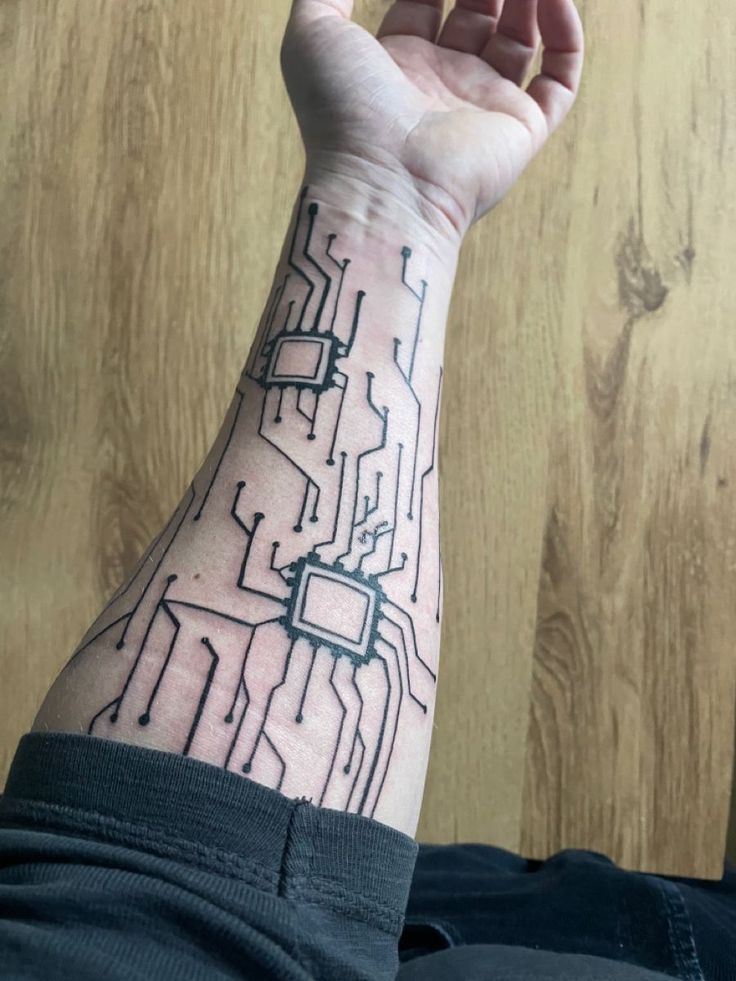 a man's arm with a circuit board tattoo on it