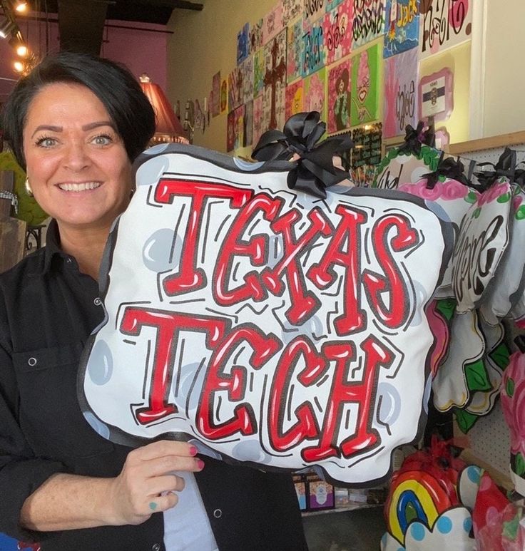 a woman holding up a sign that says tarara's tech in front of her