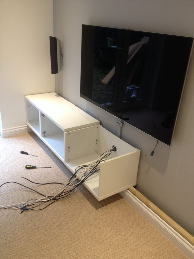 a flat screen tv sitting on top of a white entertainment center next to a wall