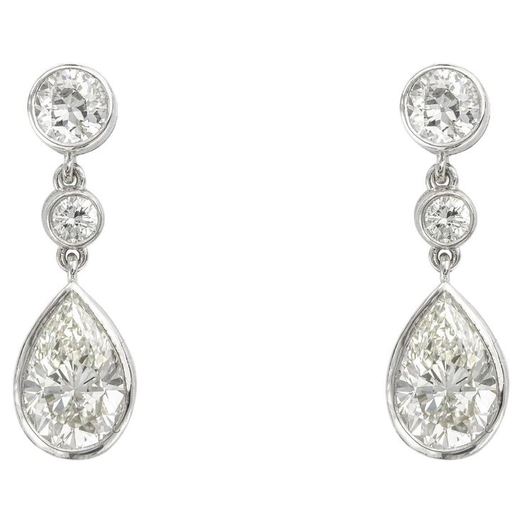 A pair of pear shape diamond drop earrings, the pear shape diamonds weighing 1.02 carats and 1.12 carats, accompanied by GIA reports, stating the diamonds to be of J colour and VS2 clarity, each suspended from two graduating round brilliant-cut diamonds weighing approximately 0.7 carats in total for the pair, all rub-over set in platinum mount with pin and C-scroll fittings, hallmarked platinum London, 2016, bearing the Bentley and Skinner sponsor mark, measuring 2.2 x 0.7cm, gross weight 5.3 gr Luxury Teardrop Platinum Jewelry, Luxury Modern Pear-shaped Earrings, Diamond Drop Pendant, Dazzling Earrings, Hairdos For Curly Hair, Her Majesty The Queen, Diamond Drops, Pear Shaped Diamond, Girly Jewelry