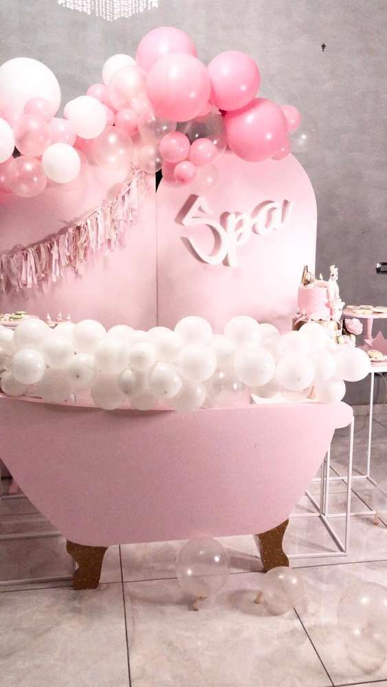 a pink bathtub with balloons on it