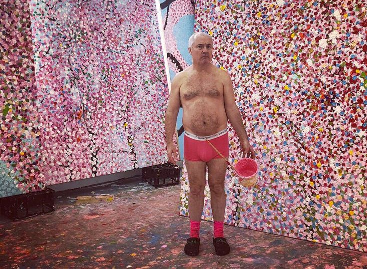 a man standing in front of a wall covered with lots of colorful confetti