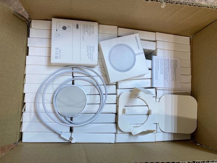 an open box containing several electronic devices and cables, including one for the apple watch