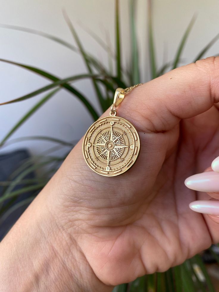 Introducing the Compass Pendant Necklace, a striking piece of jewelry crafted from high-quality 925 sterling silver and 14K solid gold. This handmade necklace features a detailed pendant adorned with a compass design, symbolizing guidance, adventure, and exploration. Perfect for those who appreciate meaningful and symbolic accessories, this necklace is available in customizable chain lengths of 16, 18, 20, and 22 inches. -Material: 14K Solid Gold / 925 Sterling Silver -Pendant Size: Customizable 14k Gold Medallion Amulet Jewelry, Tarnish Resistant Brass Medallion Jewelry, Gold Amulet Jewelry With Polished Finish, Spiritual 14k Gold Jewelry Stamped 14k, 14k Gold Amulet Jewelry With Coin Pendant, Symbolic 14k Gold Medallion Jewelry, Amulet Style Jewelry With Polished Finish As Gift, Gift Amulet Jewelry With Polished Finish, Rose Gold Sterling Silver Medallion Jewelry