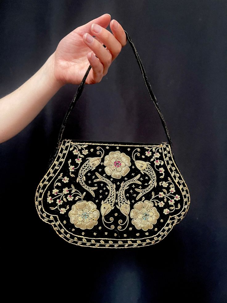 Item Details. From India a beautiful traditional md 20th century silver Zardozi embroidered purse or bag worked in real silver thread onto black cotton velvet. If you have ever seen an Indian bride wearing a traditional wedding outfit, you couldn't help noticing the elaborate embroidery that her dress was richly decorated with. It is the famous zardozi embroidery.  This ancient art has been mentioned as far back as the Rigveda, where it has been described as the attire of gods. It used to be a privilege enjoyed only by aristocrats and royalty. Maharajahs wore ceremonial cloths decorated with zardozi; elaborate panels were hung on their walls and for ceremonial processions their elephants and horses were adorned with zardozi spreads and saddles. This pretty purse is hand worked in silver wr Traditional Embroidered Formal Bag, Ravens Aesthetic, Vintage Gold Bags With Handwork, Vintage Gold Bag With Handwork, Luxury Bags With Intricate Embroidery, Indian Bags, Luxury Vintage Embroidered Bag, Gold Vintage Embroidered Evening Bag, Antique Gold Embroidered Bags