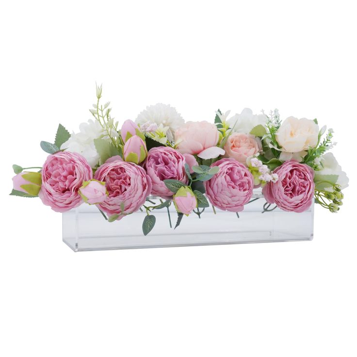 pink and white flowers are arranged in a clear glass vase with greenery on the side