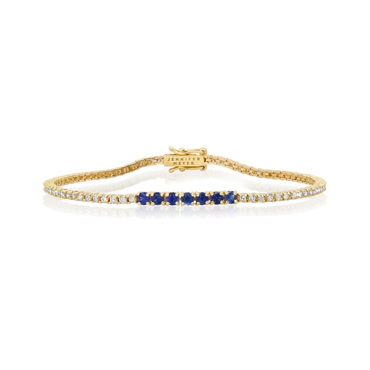 A true classic, our Diamond Four Prong Tennis Bracelet is accented with larger four prong set blue sapphires at the center. Handcrafted in 18-karat yellow gold and set with 1.50 carats of round, brilliant-cut white diamonds this bracelet has timeless appeal - the perfect gift for yourself or someone you love, because diamonds are always a good idea! Bracelet measures 6.5 inches in length Diamond Carat Weight: 1.50 ct Blue Sapphire Carat Weight: 0.53 ct Stone size: 1.5 mm / Accent - 2.5 mm Diamon Classic Yellow Gold Diamond Bracelet With Channel Set, Classic Yellow Gold Bracelet With Channel Set, Classic Yellow Gold Diamond Bracelet Channel Set, Classic Yellow Gold Channel Set Diamond Bracelet, Classic Yellow Gold Bracelet Channel Set, Classic Yellow Gold Bracelets Channel Set, Sapphire Tennis Bracelet Fine Jewelry With Prong Setting, Classic Sapphire-colored Cubic Zirconia Bracelets, Classic Sapphire Tennis Bracelet With Prong Setting