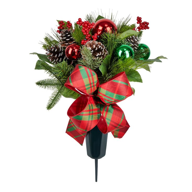 a christmas arrangement with pine cones, holly and baubes in a black vase