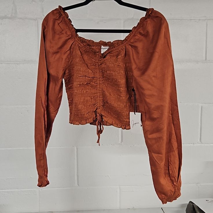 Gorgeous Soft Top. Nwt Never Worn. Beautiful Rusty Orange Color. Smocked And Cropped With Ties. Ruffled Neckline And Puffy Sleeves. Size Large But Looks Small, Probably Could Work For Small/Medium. Smoke-Free Home Brown Long Sleeve Top With Ruched Detail, Long Sleeve Brown Top With Ruched Detail, Casual Smocked Top With Elastic Sleeves For Fall, Fitted Brown Smocked Top With Smocked Back, Casual Smocked Top With Long Sleeves And Elastic Neckline, Fall Bohemian Top With Elastic Sleeves, Casual Smock Brown Tops, Casual Long Sleeve Smocked Top With Elastic Neckline, Stretch Long Sleeve Smocked Top With Ruched Detail