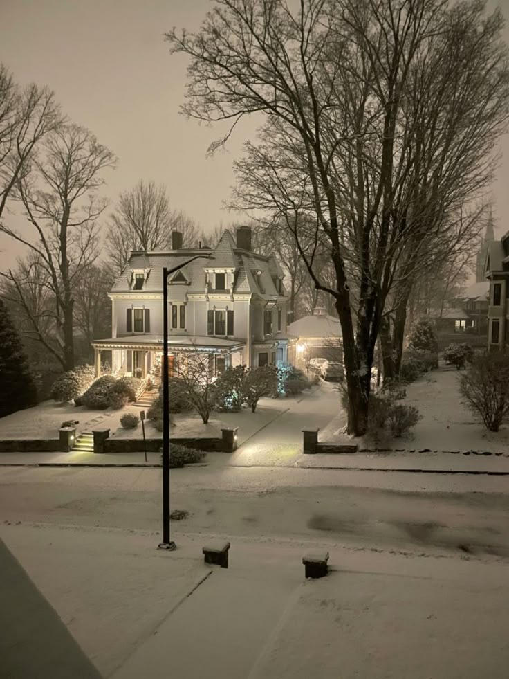 a house is lit up with christmas lights in the snow