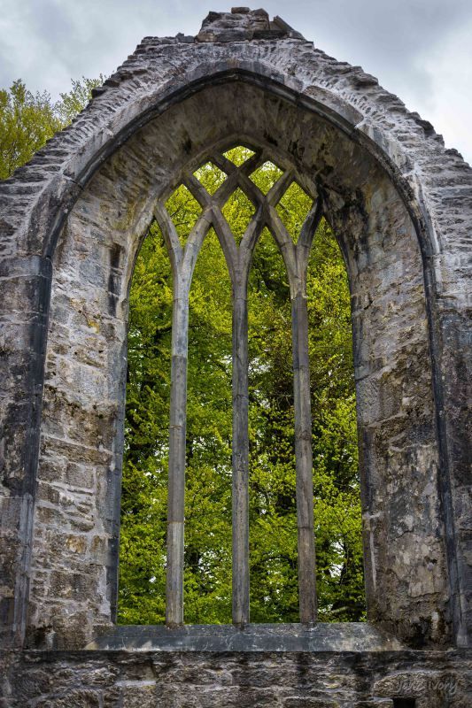 an old stone window with trees in the background